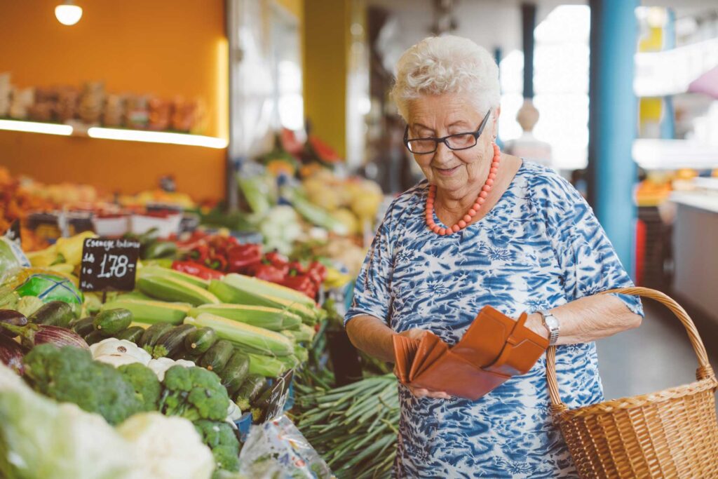 Elderly woman buying groceries.